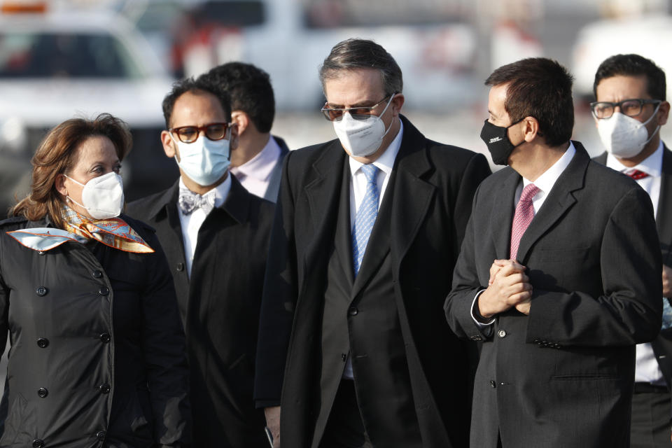 Mexican Foreign Minister Marcelo Ebrard walks with other government officials at the Benito Juarez International Airport to receive the first shipment of the Pfizer COVID-19 vaccine in Mexico City, Wednesday, Dec. 23, 2020. (AP Photo/Eduardo Verdugo)