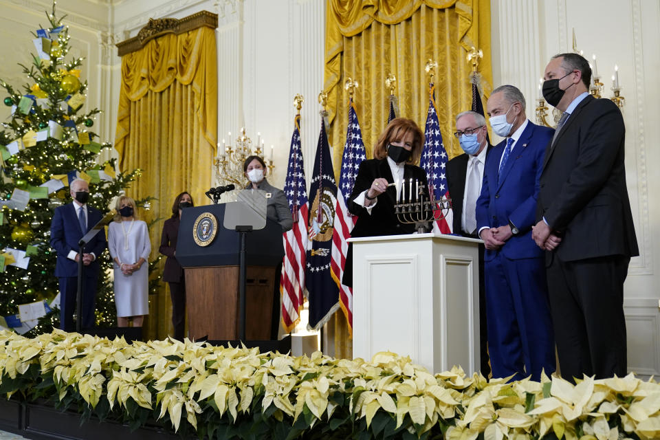 President Joe Biden and first lady Jill Biden, left, watch as Jewish community leader Susan Stern lights a menorah in the East Room of the White House in Washington, during an event to celebrate Hanukkah, Wednesday, Dec. 1, 2021. Others participating are, from left, Vice President Kamala Harris, Rabbi Lauren Holtzblatt, Dr. Rabbi Aaron Glatt, Senate Majority Leader Chuck Schumer of N.Y., and second gentleman Doug Emhoff. (AP Photo/Susan Walsh)