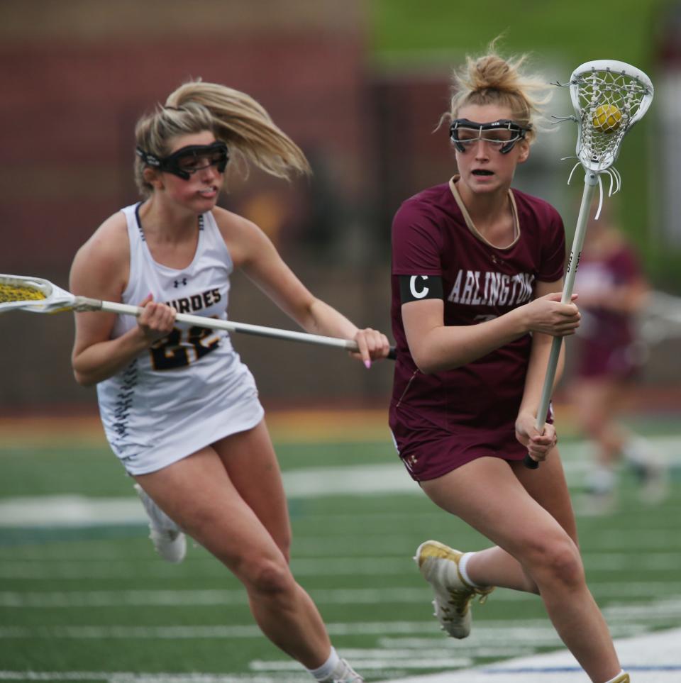 Arlington's Shannon Cunningham leads the ball away from Lourdes' Alaina Sells during Tuesday's game on May 3, 2022. 