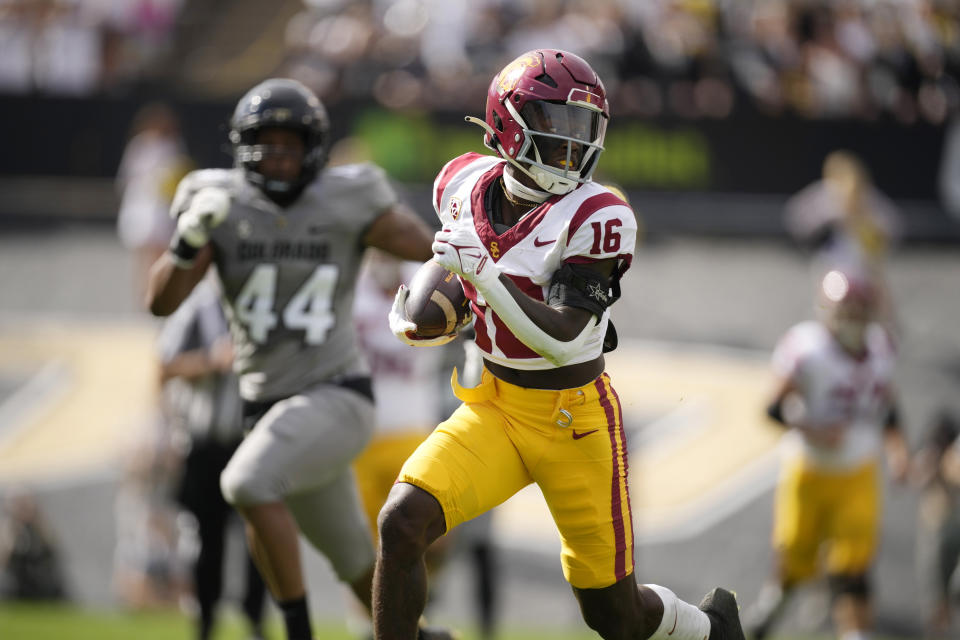 Southern California wide receiver Tahj Washington, front, runs for a touchdown after pulling in a pass as Colorado linebacker Jordan Domineck pursues in the first half of an NCAA college football game Saturday, Sept. 30, 2023, in Boulder, Colo. (AP Photo/David Zalubowski)