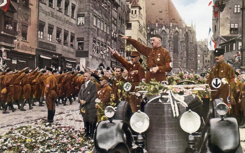 August 1927: Adolf Hitler, saluting the massed ranks of his party during the party congress at Nuremberg - Hulton Archive