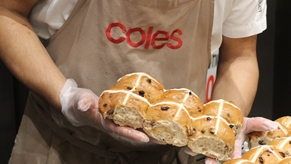 Coles hot cross buns image of baker with Coles logo holding them