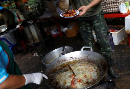 A soldier cooks for rescue workers at the Tham Luang cave complex, where 12 schoolboys and their soccer coach are trapped inside a flooded cave, in the northern province of Chiang Rai, Thailand, July 7, 2018. REUTERS/Soe Zeya Tun