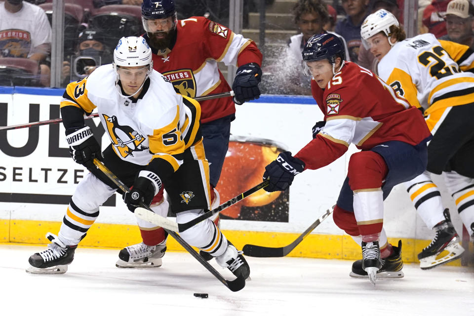 Pittsburgh Penguins center Teddy Blueger (53) skates with the puck as Florida Panthers center Anton Lundell (15) defends during the first period of an NHL hockey game Thursday, Oct. 14, 2021, in Sunrise, Fla. (AP Photo/Lynne Sladky)