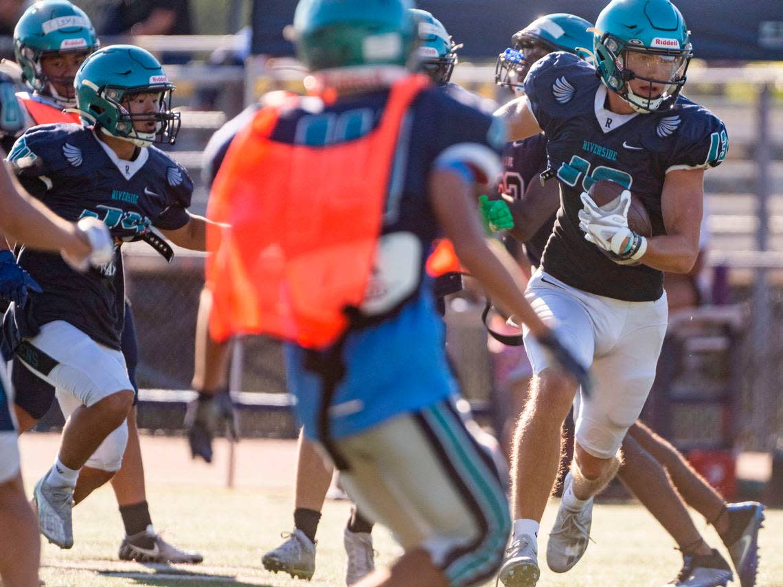 Auburn Riverside receiver Jace Villers (right) splits through the defense after catching a pass during team drills on Monday, Aug. 22, 2022, at Auburn Riverside High School in Auburn, Wash.