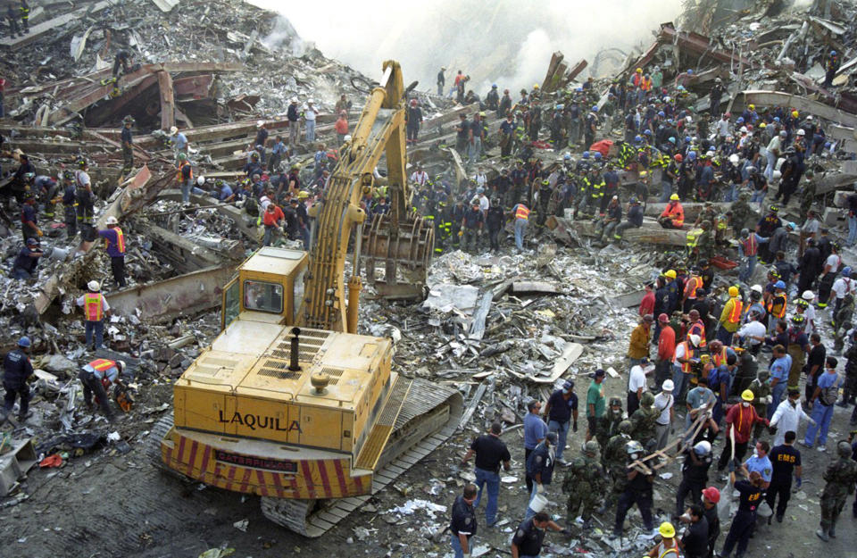 A digger clearing rubble as emergency services personell search for survivors. (Caters)