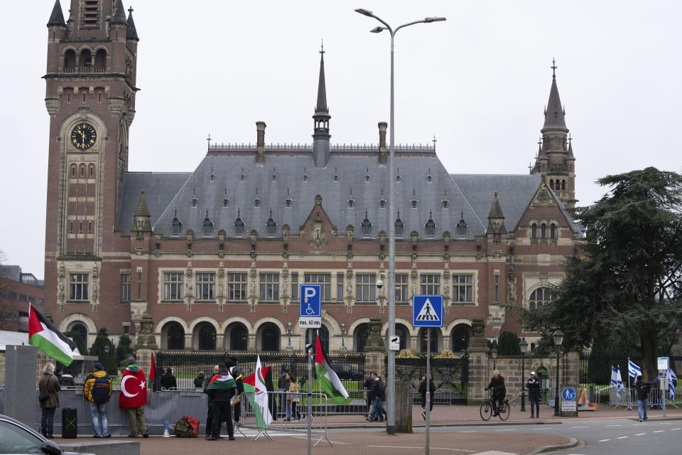 Pro-Palestinian, left, and pro-Israeli demonstrators, right, protest outside the United Nations' highest court, rear, during historic hearings in The Hague, Netherlands, Wednesday, Feb. 21, 2024, into the legality of Israel's 57-year occupation of the West Bank and east Jerusalem, plunging the 15 international judges back into the heart of the decades-long Israeli-Palestinian conflict. Six days of hearings at the International Court of Justice, during which an unprecedented number of countries will participate in proceedings, are scheduled as Israel continues its devastating assault on Gaza. (AP Photo/Peter Dejong)