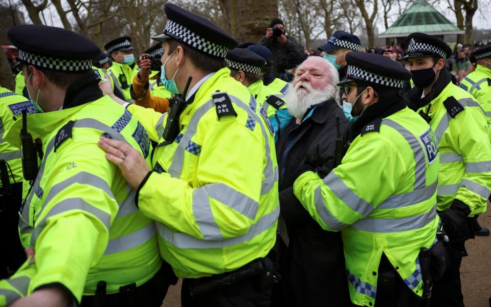 Police officers on the frontline detain a demonstrator in Hyde Park during a protest against the lockdown - HENRY NICHOLLS/REUTERS