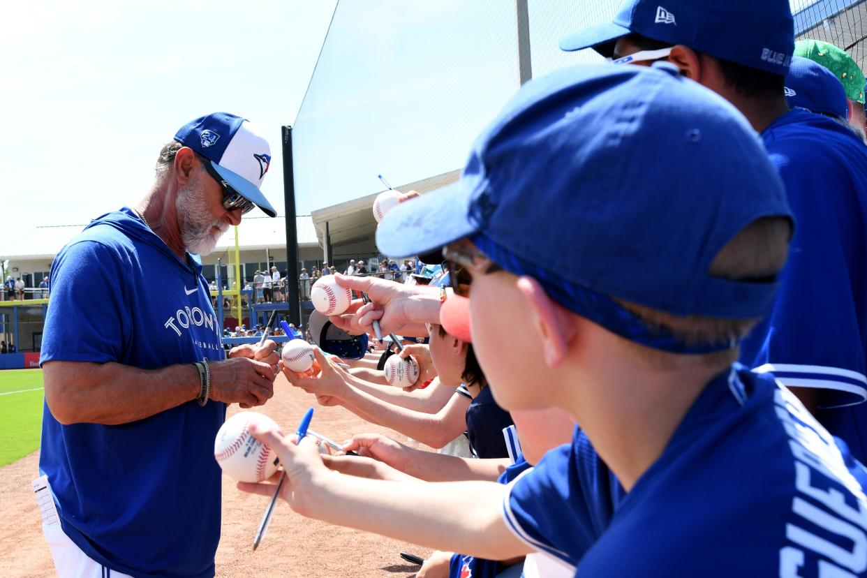 Mar 15, 2024; Dunedin, Florida, USA; Toronto Blue Jays bench coach Don Mattingly (23) signs autographs before the start of the spring training game against the Detroit Tigers at TD Ballpark. Mandatory Credit: Jonathan Dyer-USA TODAY Sports