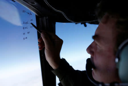 Squadron leader Brett McKenzie marks the name of another search aircraft on the windshield of a Royal New Zealand Air Force P-3K2 Orion aircraft searching for missing Malaysian Airlines flight MH370 over the southern Indian Ocean March 22, 2014. REUTERS/Jason Reed/File Photo