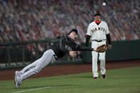 Colorado Rockies third baseman Ryan McMahon makes a diving catch on a pop foul by San Francisco Giants' Joey Bart in front of Giants third base coach Ron Wotus during the fourth inning of a baseball game Wednesday, Sept. 23, 2020, in San Francisco. (AP Photo/Tony Avelar)