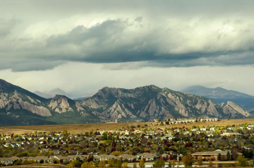 Urban sprawl from the developments in Broomfield, Colorado apprach the majestic range of the Flatiron Mountains.