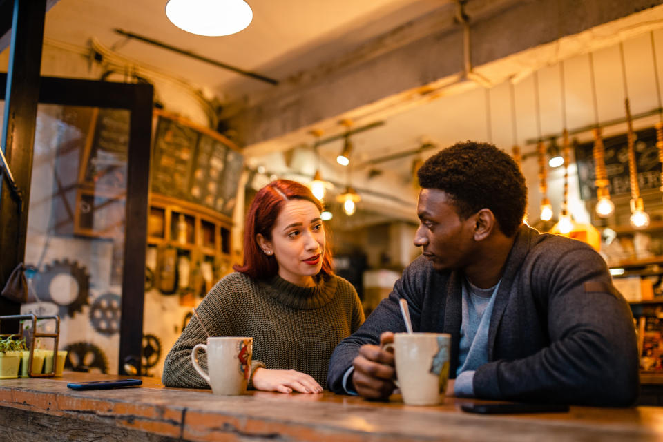 Two people having an intimate conversation over coffee at a cafe table