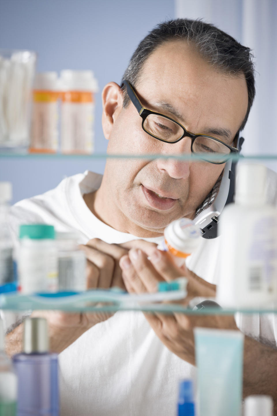 A person holding pills while on the phone