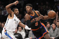 New York Knicks guard RJ Barrett (9) drives against Brooklyn Nets guard Kyrie Irving during the first half of an NBA basketball game, Saturday, Jan. 28, 2023, in New York. (AP Photo/Mary Altaffer)