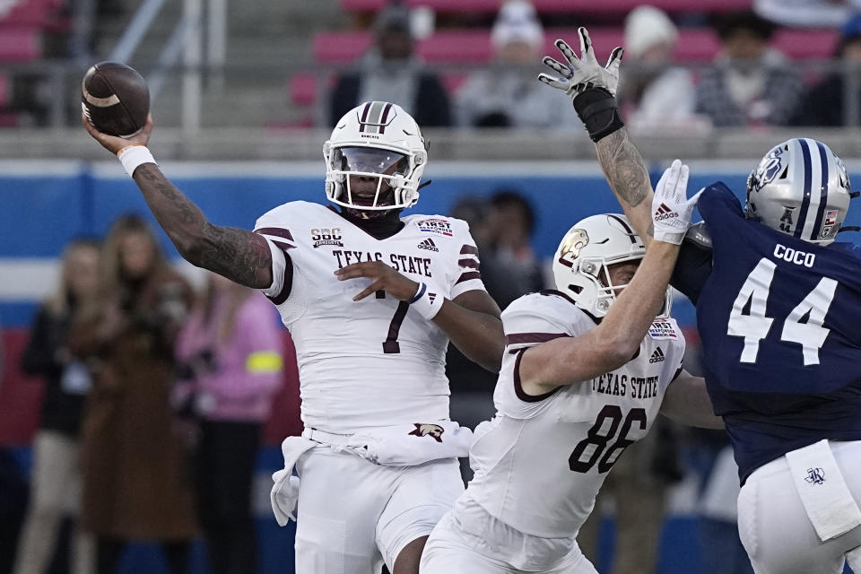 Texas State quarterback TJ Finley (7) throws a pass as tight end Titus Lyons (86) blocks Rice defensive end Coleman Coco (44) during the first half of the First Responder Bowl NCAA college football game Tuesday, Dec. 26, 2023, in Dallas. (AP Photo/LM Otero)