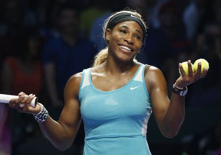 Serena Williams of the U.S. smiles to the crowd after defeating Eugenie Bouchard of Canada during their WTA Finals singles tennis match at the Singapore Indoor Stadium October 23, 2014. REUTERS/Edgar Su