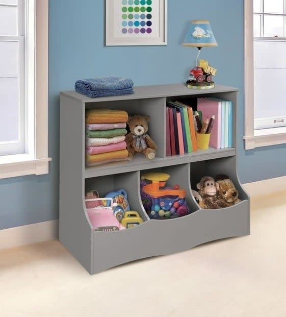 Gray children's storage unit with shelves and toy bins in a room