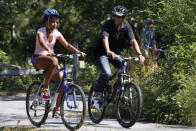 President Barack Obama (R) and daughter Malia Obama, 13, bike together on a bike path through Manuel F. Correllus State Forest while vacationing on Martha's Vineyard on August 23, 2011 in West Tisbury, Massachusetts. This is the third year the president has taken hi