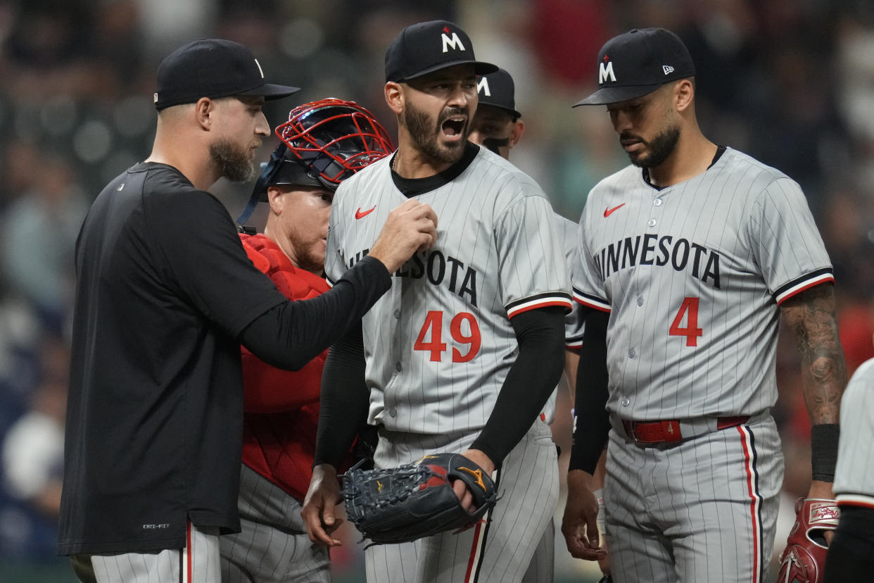 Minnesota Twins starting pitcher Pablo Lopez (49) reacts as he is taken out of the game by manager Rocco Baldelli, left, in the seventh inning of a baseball game, Monday, Sept. 16, 2024, in Cleveland. Twins's Carlos Correa is at right. (AP Photo/Sue Ogrocki)