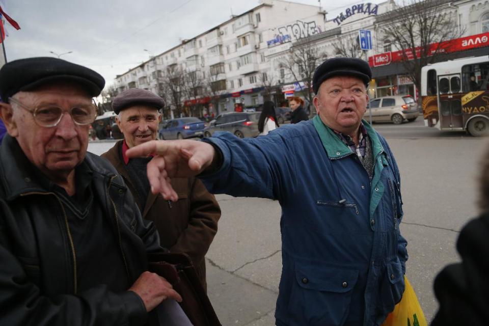 In this photo taken Wednesday, March 5, 2014, local people discuss the situation at a central square in Simferopol, Ukraine. Ukraine is facing a potentially crippling geographic and cultural divide, a growing gulf between supporters of Russia who dominate the east and south of the country, and western Ukrainians who yearn for closer ties to Western Europe. One side of that divide is even starker in Crimea, a Black Sea peninsula. For much of the past 200 years, Crimea was under Russian and Soviet control, and today most Crimeans see themselves as only nominally Ukrainian and Russian is, by far, the dominant language (AP Photo/Sergei Grits)