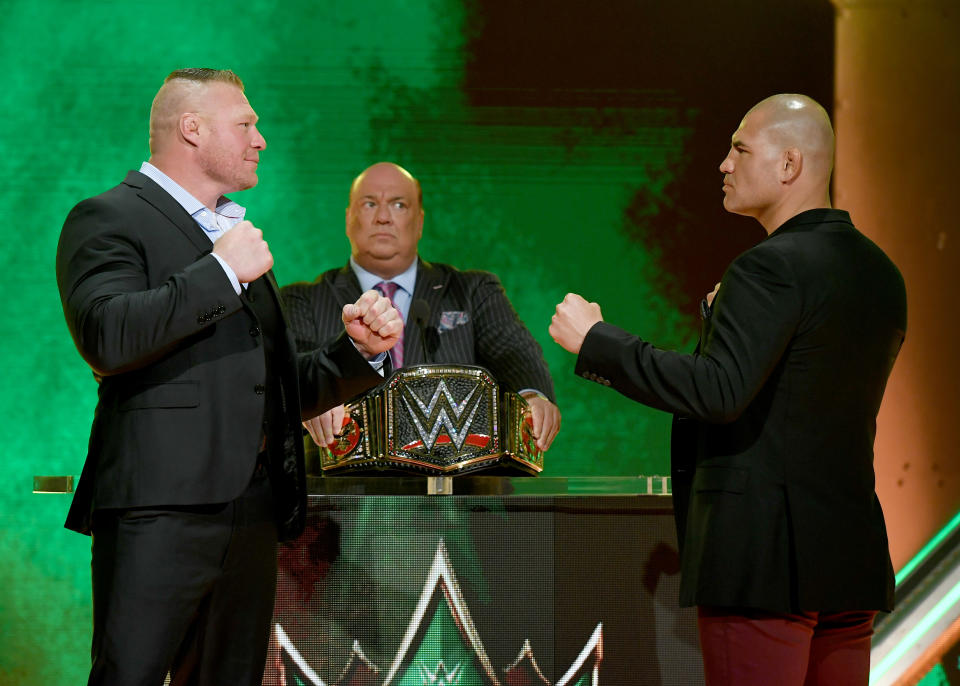 LAS VEGAS, NEVADA - OCTOBER 11:  WWE champion Brock Lesnar (L) and former UFC heavyweight champion Cain Velasquez (R) face off as Lesnar's advocate Paul Heyman (C) looks on during the announcement of their match at a WWE news conference at T-Mobile Arena on October 11, 2019 in Las Vegas, Nevada. Lesnar will face Velasquez and WWE wrestler Braun Strowman will take on heavyweight boxer Tyson Fury at the WWE's Crown Jewel event at Fahd International Stadium in Riyadh, Saudi Arabia on October 31.  (Photo by Ethan Miller/Getty Images)