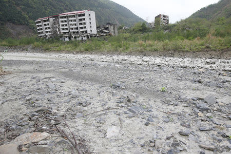 Buildings which were destroyed in the 2008 Sichuan earthquake stand alongside a dry riverbed in the city of Beichuan, Sichuan province, China, April 6, 2018. REUTERS/Jason Lee