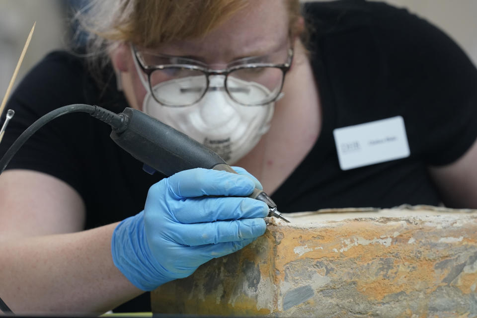 Conservator for the Virginia Department of Historic Resources, Chelsea Blake, works to open a time capsule that was removed form the pedestal that once held the statue of Confederate General Robert E. Lee on Monument Ave. Wednesday Dec. 22, 2021, in Richmond, Va. (AP Photo/Steve Helber)