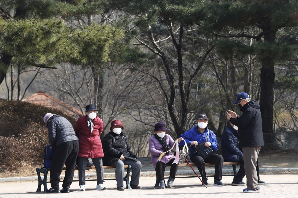 People wearing face masks as a precaution against the coronavirus gather at a park in Goyang, South Korea, Wednesday, March 10, 2021. (AP Photo/Ahn Young-joon)