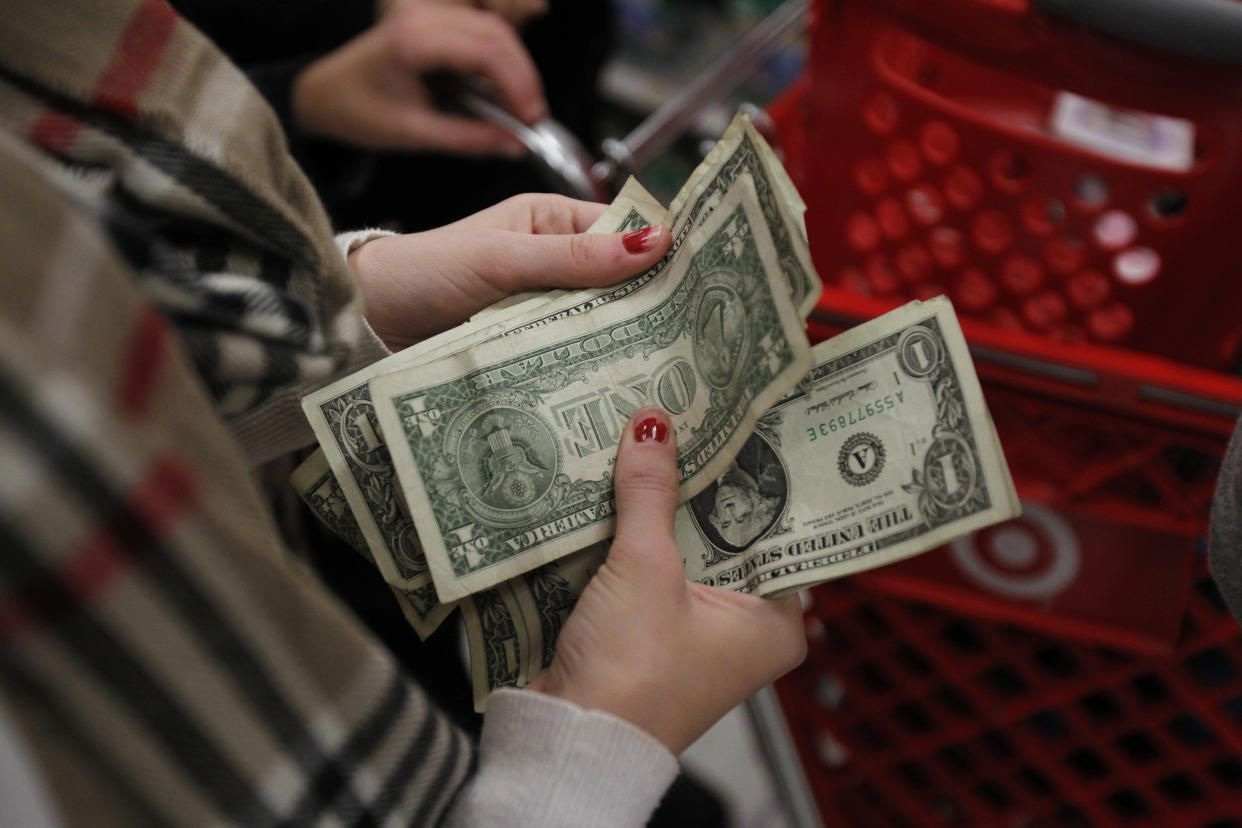A customer counts her money while waiting in line to check out at a Target store.
