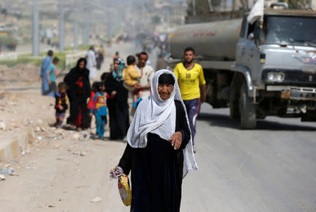 Displaced Iraqis walk as they flee after a battle between the Iraqi Counter Terrorism Service and Islamic State militants in western Mosul, Iraq, April 22, 2017. REUTERS/Muhammad Hamed