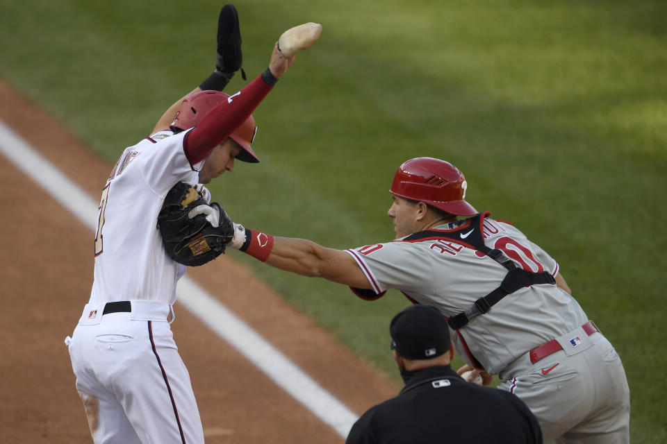 Philadelphia Phillies catcher J.T. Realmuto (10) reaches for Washington Nationals' Trea Turner, left, with his glove as he holds onto the ball in his right hand during the third inning of the first baseball game of a doubleheader, Tuesday, Sept. 22, 2020, in Washington. Turner was eventually out on the play. (AP Photo/Nick Wass)