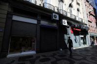 A man walks and passes by the partially closed shops after authorities announced measures due to the outbreak of coronavirus disease (COVID-19), in downtown of Rio de Janeiro