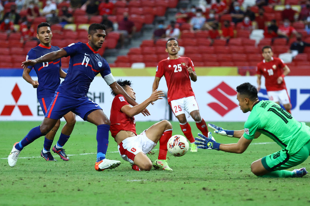 Singapore captain Hariss Harun (left) and goalkeeper Hassan Sunny combine to foil an attempt by Indonesia's Witan Sulaeman during their AFF Suzuki Cup semi-final clash.