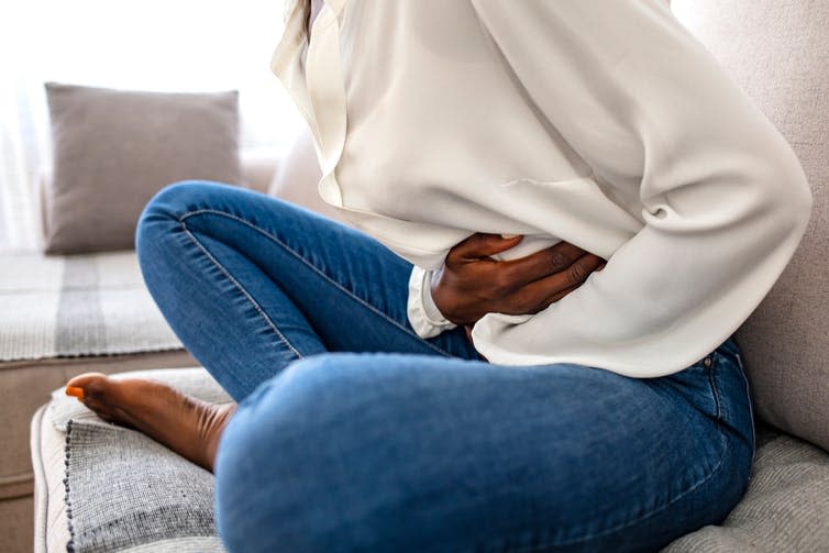 A woman clutching her stomach.