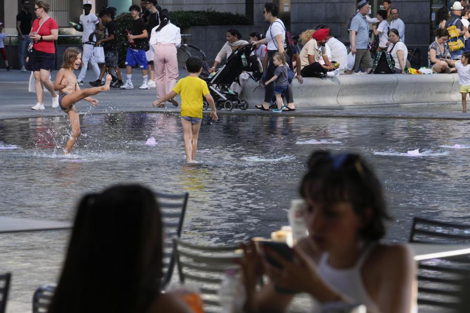 Children cool off in a public fountain in Milan, Italy, Saturday, July 15, 2023. Temperatures reached up to 42 degrees Celsius in some parts of the country, amid a heat wave that continues to grip southern Europe. (AP Photo/Luca Bruno)