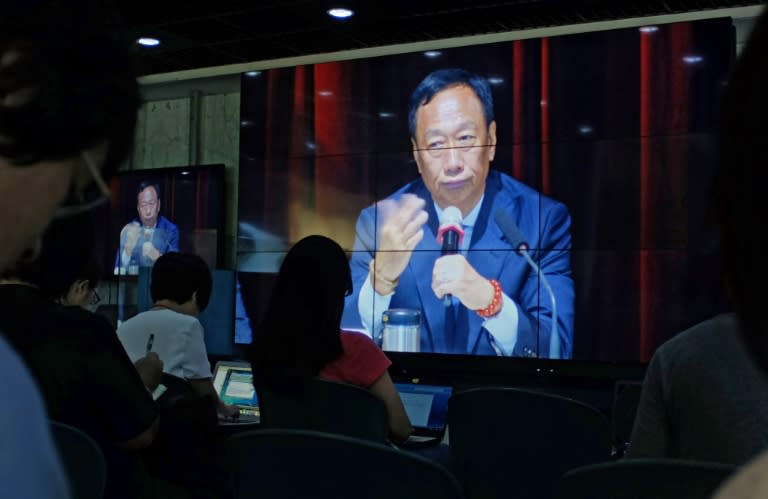 Journalists (in foreground) watch a large video screen showing Terry Gou, founder of Foxconn parent Hon Hai group, during a shareholders conference at the company's headquarters in Tucheng in New Taipei City on June 22, 2016