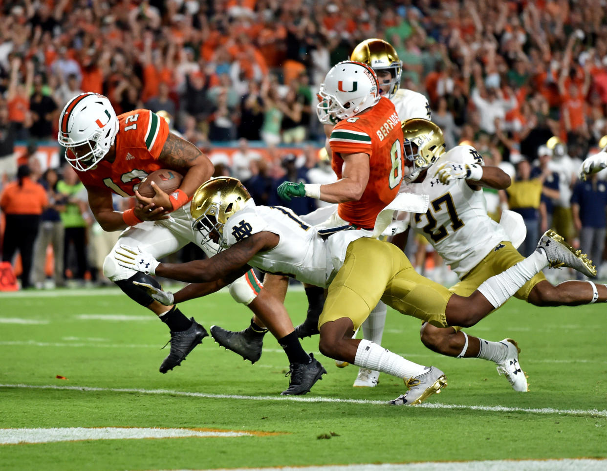 Nov 11, 2017; Miami Gardens, FL, USA; Miami Hurricanes quarterback Malik Rosier (12) scores a touchdown as Notre Dame Fighting Irish safety Devin Studstill (14) defends during the first half at Hard Rock Stadium. Mandatory Credit: Steve Mitchell-USA TODAY Sports TPX IMAGES OF THE DAY