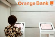 A woman performs a financial transaction at a bank of the French mobile operator Orange in Abidjan, Ivory Coast