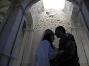 Newlyweds, soldier Hovhannes Hovsepyan, right, and Mariam Sargsyan hug after their wedding ceremony in the Holy Savior Cathedral, damaged by shelling by Azerbaijan's artillery during a military conflict in Shushi, the separatist region of Nagorno-Karabakh, Saturday, Oct. 24, 2020. The wedding was celebrated even as intense fighting in the region has continued. (AP Photo)