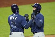 Tampa Bay Rays' Willy Adames, right, and Yandy Diaz (2) celebrate after Adames scored on a single by Kevin Kiermaier during the fifth inning of a baseball game against the Kansas City Royals, Monday, April 19, 2021, in Kansas City, Mo. (AP Photo/Charlie Riedel)