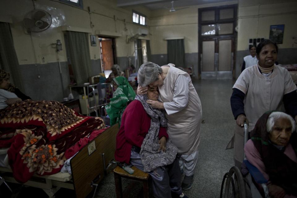 In this Sunday, Feb. 16, 2014, photo, Margret Walsh, center, an Irish nun who has run St. Joseph’s Hospice as the chief administrator since 2009, comforts, Halima Fatimah, a patient and resident of the hospice, while checking the wards, part of her daily routine, in Rawalpindi, Pakistan. Mohammed Aqeel spent weeks at home in Pakistan waiting for death after suffering a debilitating spinal cord injury in a car crash before friends suggested he come to St. Joseph’s Hospice on the outskirts of the capital, Islamabad. Now 13 years later, his life and those of some 40 others who live on its grounds might be changed forever as this hospital of last resort faces closure over its rising debts. (AP Photo/Muhammed Muheisen)