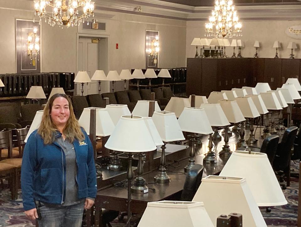The public liquidation sale of the contents of the former Bel-Aire Hotel in Millcreek Township starts on Thursday. On Wednesday, Nicole Kabealo, project manger for International Content Liquidations Inc., of Dayton, Ohio, stands in the Bel-Aire ballroom, where lamps, chandeliers and tables are labeled for sale.