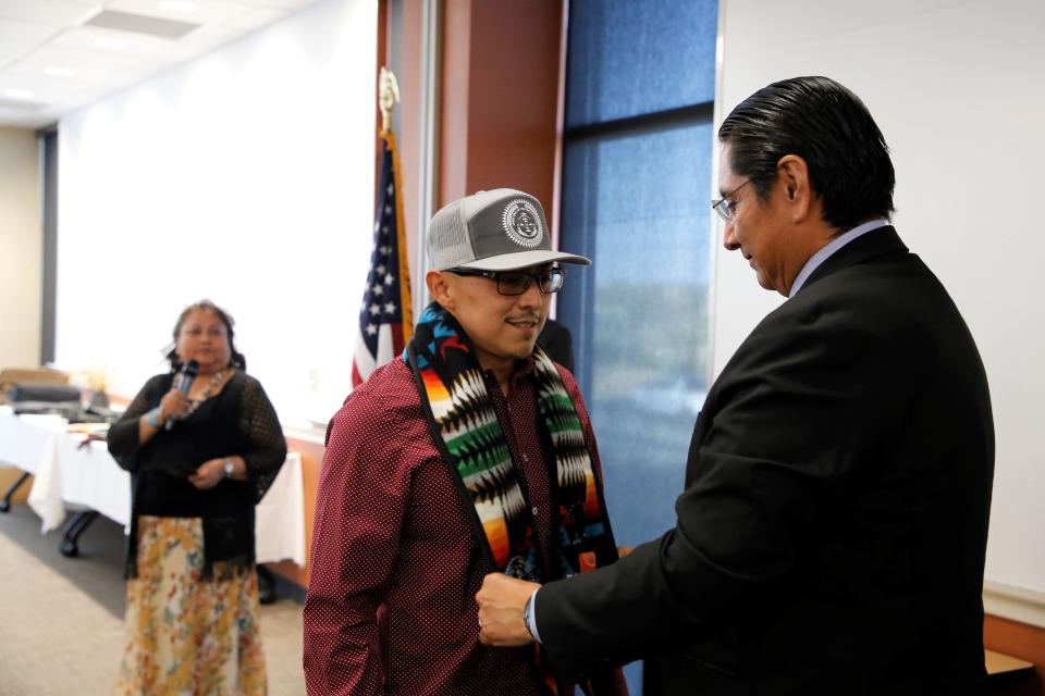 Navajo Technical University student Aaron Billy receives his graduation stole from Navajo Nation President Jonathan Nez during a reception on May 10 in Farmington to recognize graduating students in the Public Service Company of New Mexico's Navajo Nation Workforce Training Initiative.