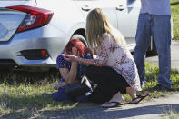 <p>A woman consoles another as parents wait for news regarding a shooting at Marjory Stoneman Douglas High School in Parkland, Fla., on Feb. 14, 2018. (Photo: Joel Auerbach/AP) </p>