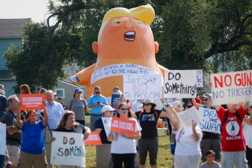 Demonstrators gather to protest the arrival of President Donald Trump outside Miami Valley Hospital after a weekend mass shooting that occurred in the Oregon District, Wednesday, Aug. 7, 2019, in Dayton. Twenty-four-year-old Connor Betts open