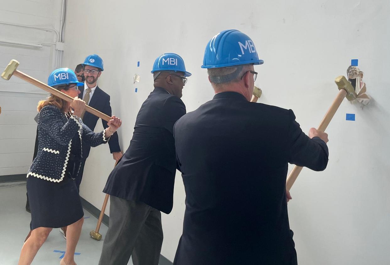 Lt. Gov. Karyn Polito and other officials take sledgehammers to a wall during the groundbreaking ceremony for the expansion of Massachusetts Biomedical Initiatives' biomedical center Wednesday.