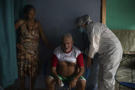 Francisco de Oliveira, 77, takes a deep breath while Doctor Dayanne Araujo listens to his lungs in Manacapuru, Amazonas state, Brazil, Tuesday, June 2, 2020. Oliveira is waiting for his COVID-19 test results after feeling weakness, difficulty breathing and other symptoms. (AP Photo/Felipe Dana)