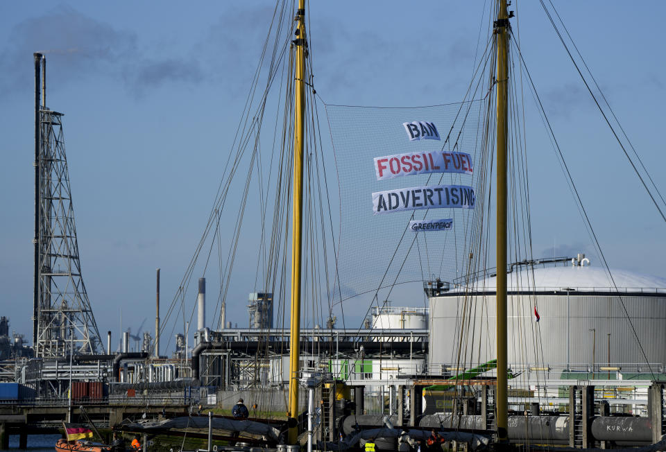 Greenpeace's Beluga II carries a banner reading "Ban Fossil Fuel Advertising" as it blocks part of the port at a Shell refinery in Rotterdam, Netherlands, Monday, Oct. 4, 2021. A coalition of environmental groups launched a campaign calling for a Europe-wide ban on fossil fuel advertising ahead of the United Nations Climate Change Conference, also known as COP26, which start in Glasgow on Oct. 31st, 2021. (AP Photo/Peter Dejong)