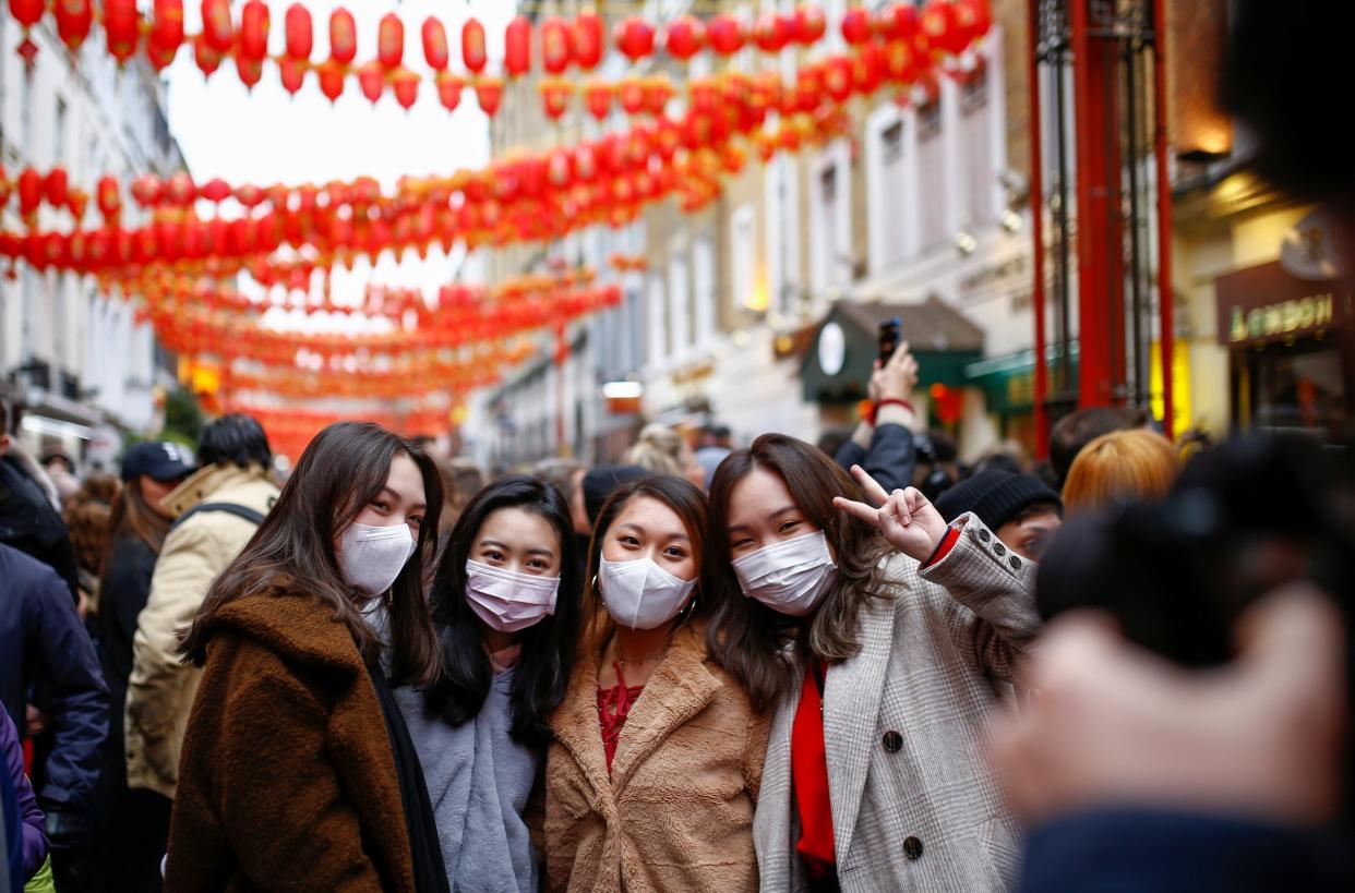 People wear masks as they pose for a picture during Chinese Lunar New Year celebrations: REUTERS